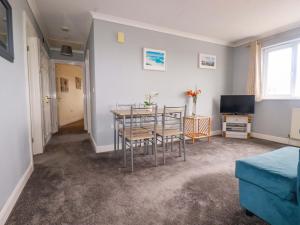 a living room with a table and chairs and a television at Treetops in Par