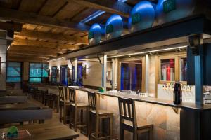 a restaurant with a bar with wooden chairs and blue accents at Wellness penzión Predná Hora in Muráň