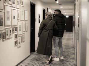 a man and a woman looking at art on a wall at The Sebel Canberra Civic in Canberra