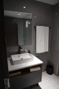 a bathroom with a white sink and a mirror at Happiness Hotel Ulaanbaatar in Ulaanbaatar