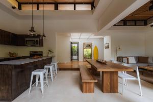 a kitchen and living room with a wooden table and chairs at Nalu Nosara Pool Villa Flor in Nosara