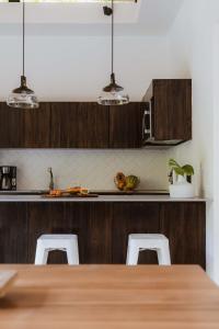 a kitchen with wooden cabinets and a table and chairs at Nalu Nosara Pool Villa Flor in Nosara