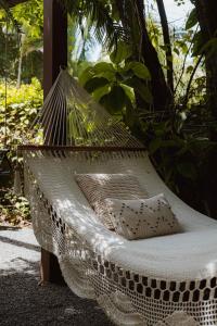a net hammock with a pillow sitting on it at Nalu Nosara Pool Villa Flor in Nosara