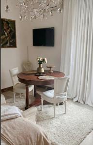a dining room with a table and chairs and a tv at Visconti suite and spa in Catania