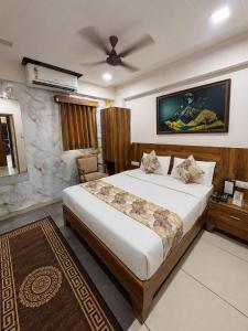 a bedroom with a bed and a ceiling fan at Star Hotel in Ahmedabad