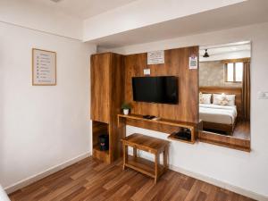 a room with a bed and a flat screen tv at Star Hotel in Ahmedabad +26 photos