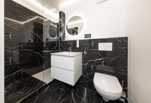 a black marble bathroom with a toilet and a sink at Ferienwohnung 210 Salinenparc Design Budget Hotel in Erwitte
