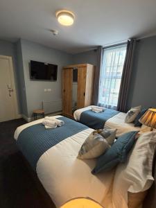 a bedroom with three beds and a tv on the wall at The Pod on John St in Wexford