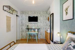 a bedroom with a table and a tv on a wall at Les Arbousiers in Saint-Raphaël