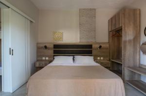 a bedroom with a large bed with a wooden headboard at Tsamakdas House in Toroni