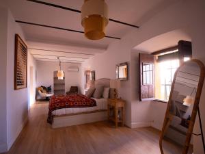 a bedroom with a bed and a couch in a room at Cortijo Negretti in Herrera de Alcántara