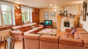 a living room with two couches and a tv at Chalupa Šumburk in Svárov