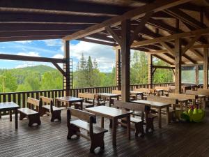 a deck with tables and benches on a wooden deck at Wellness penzión Predná Hora in Muráň