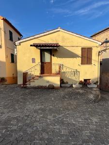 a large yellow building with a porch and a door at Casa Ravasio in Arcevia