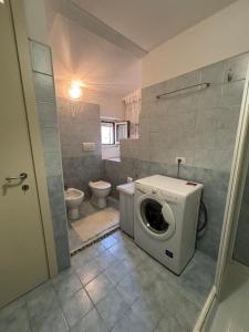 a bathroom with a washing machine and a toilet at Casa Ravasio in Arcevia