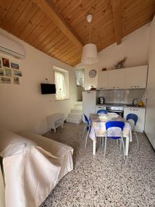 a room with a table and chairs and a kitchen at Casa Ravasio in Arcevia