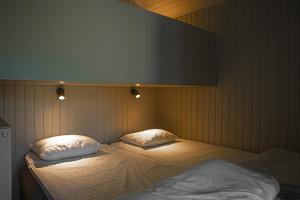 a bedroom with two beds with white sheets and pillows at Lisebergsbyns Stugor in Gothenburg