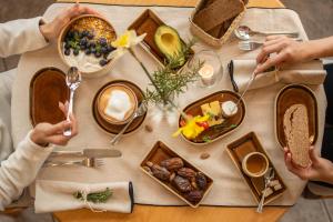 two people sitting at a table with food at Hotel Sass da Grüm in Vairano