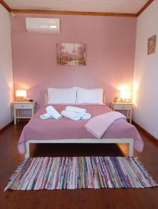 a bedroom with a bed with purple sheets and two tables at Villa Pefkias in Skopelos Town