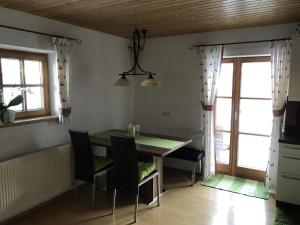 a dining room with a table and chairs and windows at Apart Lisi in Fügenberg