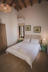 a bedroom with a white bed with two towels on it at Calliοpe's home in Skiathos