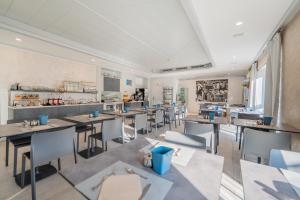 a restaurant with tables and chairs in a room at Hotel Aurora & Appartamenti in Nago-Torbole