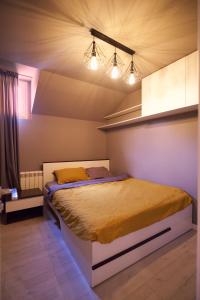 a bedroom with a bed with two lights above it at YAMM Pool House in Mali Požarevac +26 photos