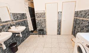 a bathroom with two sinks and a washing machine at Chalupa Šumburk in Svárov +27 photos