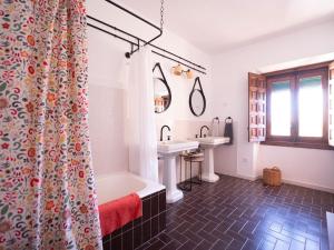 a bathroom with a shower curtain and a tub and a sink at Cortijo Negretti in Herrera de Alcántara +96 photos