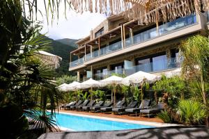 a hotel with a swimming pool with chairs and umbrellas at September15 Boutique Suites - Nikiana in Nikiana