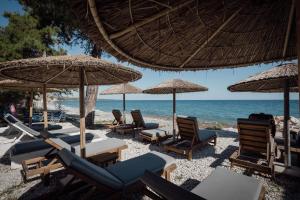 a group of chairs and umbrellas on a beach at Evriali Seaside Rooms in Platamonas