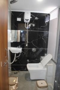 a bathroom with a toilet and a sink at Hotel Sunrise View in Ahmedabad