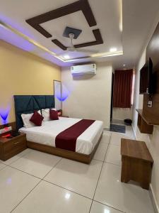 a bedroom with a bed and a ceiling with purple lights at Hotel Sunrise View in Ahmedabad