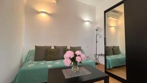 a living room with a couch and a table with flowers at Harmony Affittacamere in Riomaggiore