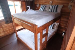 a bedroom with two bunk beds with a swan on it at Phinisi Private trip Komodo Island in Komodo Labuan Bajo Airport +4 photos