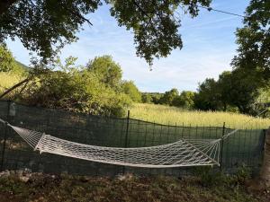 a hammock hanging on a fence in a field at Lisinj Sky Glamping in Bar