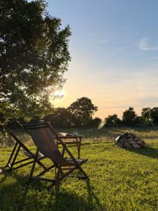 a chair sitting in the grass next to a table at Lisinj Sky Glamping in Bar