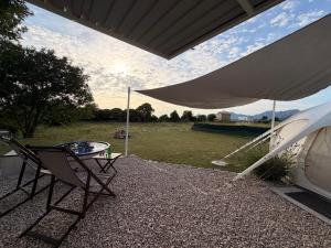a patio with two chairs and a table and a tent at Lisinj Sky Glamping in Bar