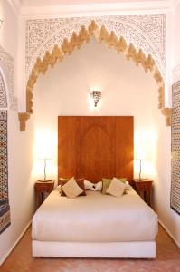 a bed with a white bedspread and pillows at Riad Dar Soufa in Rabat
