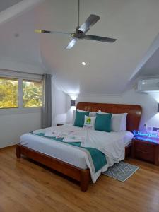 a bedroom with a bed with a ceiling fan at Treasure Island Retreat in Anse Kerlan