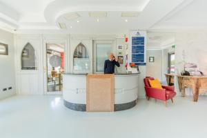 a woman standing at a counter in a room at Hotel Aurora & Appartamenti in Nago-Torbole