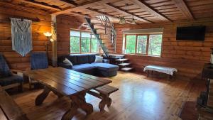 a living room with a table and a couch at Viesu māja "Ozoliņi" in Jūrkalne
