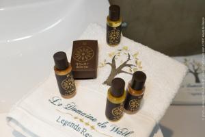 a cake with three bottles of essential oils on a towel at Le Domaine de Wail Legends Resort in Wail