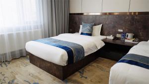 a hotel room with two beds and a desk at Happiness Hotel Ulaanbaatar in Ulaanbaatar