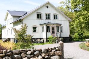 a white house with a stone wall at Anna´s Bed & Kitchen in Varberg