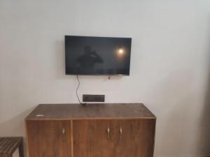 a flat screen tv on top of a wooden cabinet at Hotel Aqua Waterfall in Dharamshala
