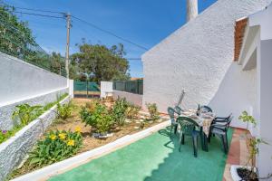 a patio with a table and chairs in a backyard at Casa Sol in Praia do Carvoeiro