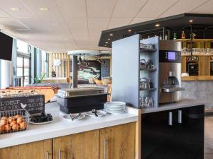 a kitchen with a counter with plates and appliances at ibis Gonesse Le Bourget in Gonesse