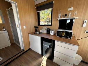 a kitchen with a counter with a laptop computer on it at The Dairy and Pines Tiny house by Tiny Away in Shadforth