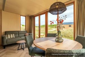 a living room with a table and chairs and a couch at Texelcampings - Kogerstrand in De Koog